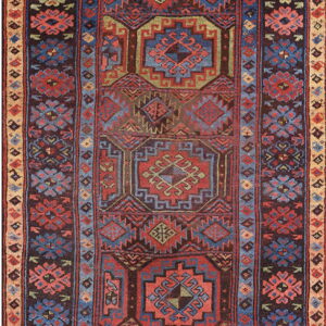 Low pile rug in deep red, blue, and brown with complex geometric and stylized floral patterns.