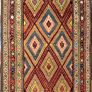 Colorful geometric rug with a field of large, interlocking diamonds and detailed multicolored borders.