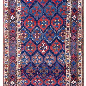 A narrow rug featuring geometric medallions in red and blue on a dark blue field with intricate borders.