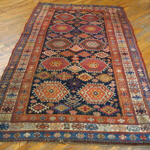 Dark geometric runner rug with red, orange, and blue medallions rests on light wood plank flooring.