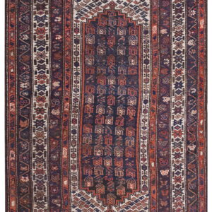 This dark blue and terracotta geometric rug has a central panel of repeating stylized house motifs.
