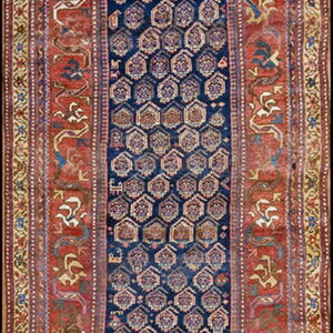 Dark blue runner rug with hexagonal motifs and wide red borders displaying stylized animal patterns.