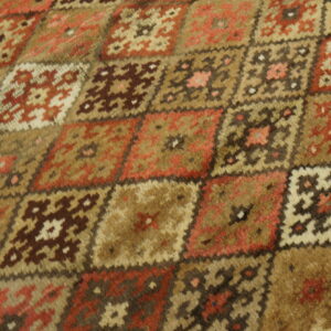 A high-pile rug with a detailed geometric pattern of interlocking squares in earthy tones.