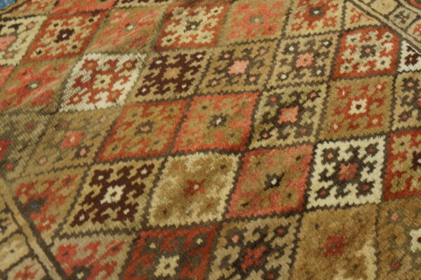 A high-pile rug with a detailed geometric pattern of interlocking squares in earthy tones.