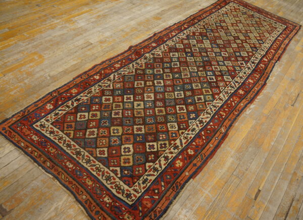 Red, blue, and tan runner featuring complex borders and a central geometric field on rustic wooden planks.