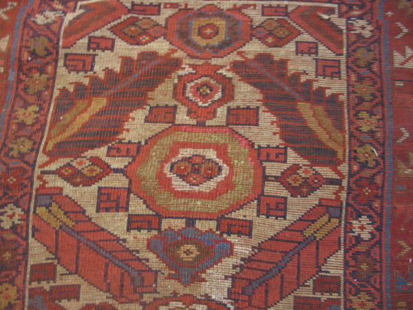 Flatweave rug detail showing a central diamond motif with geometric patterns in red, beige, and blue.