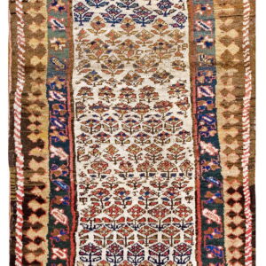 A long, narrow runner rug with a cream field, stylized red and blue tree motifs, and thick brown geometric borders.