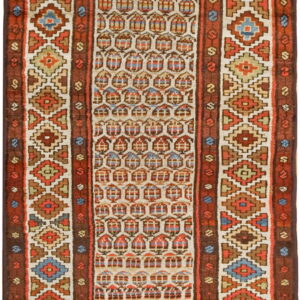 Geometric runner rug featuring stacked diamonds and repeating arched shapes in cream, rust, blue, and tan.