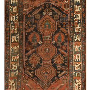 Rust and navy geometric rug with a central axis design and an elaborate border featuring stylized animal figures.