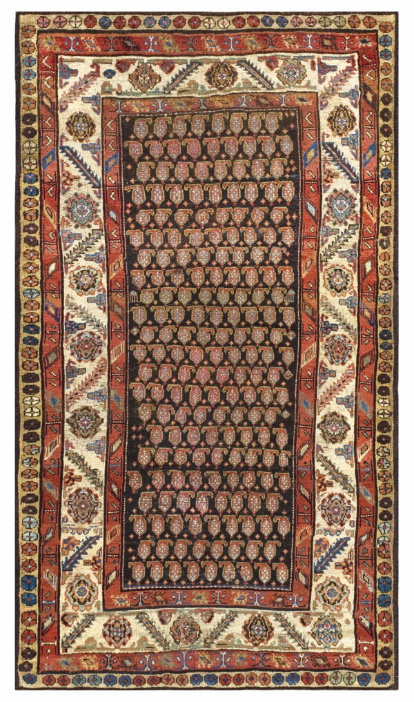 A traditional rug with a dark field, dense boteh pattern, and wide cream and rust colored borders.