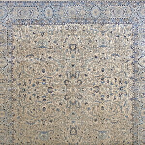 Detailed cream and blue floral rug featuring a wide border and visible stylized calligraphy in the field.