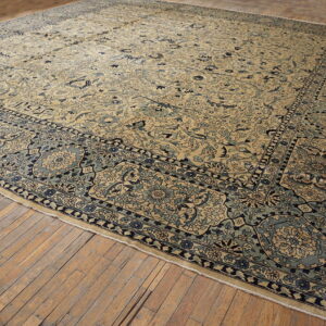 Large beige rug with dense blue floral patterns and medallions laid on light hardwood floors.