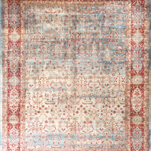 Ornate floral rug with striated blue and cream field, framed by complex red and beige borders.