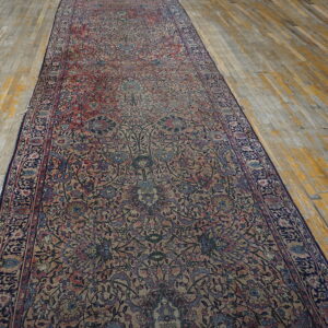 A long, ornate runner with complex red, blue, and tan floral designs covers weathered wooden floorboards.