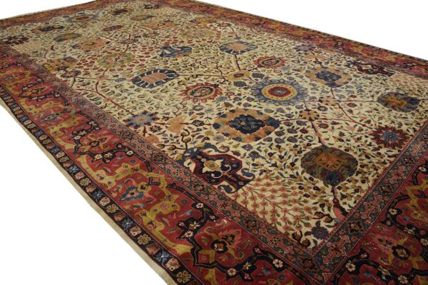 A large, low-pile rug with a cream field, ornate floral motifs, and a detailed red border.