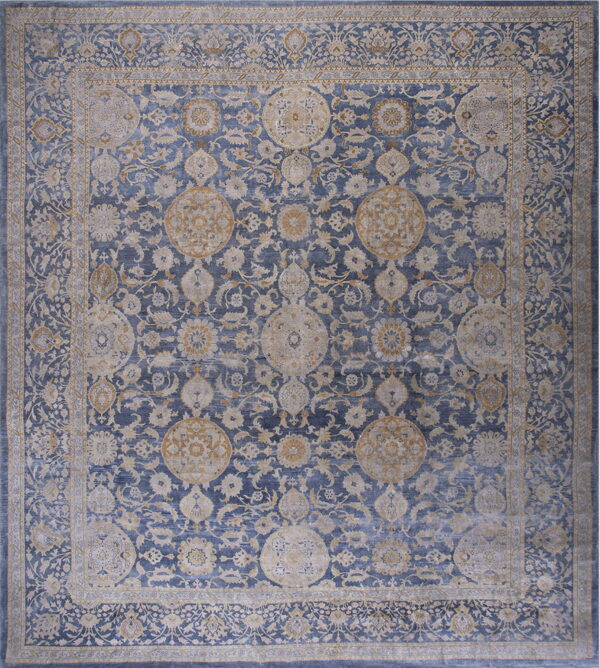 Ornate traditional rug featuring a dense floral pattern in blue, washed beige, and subtle gold tones.