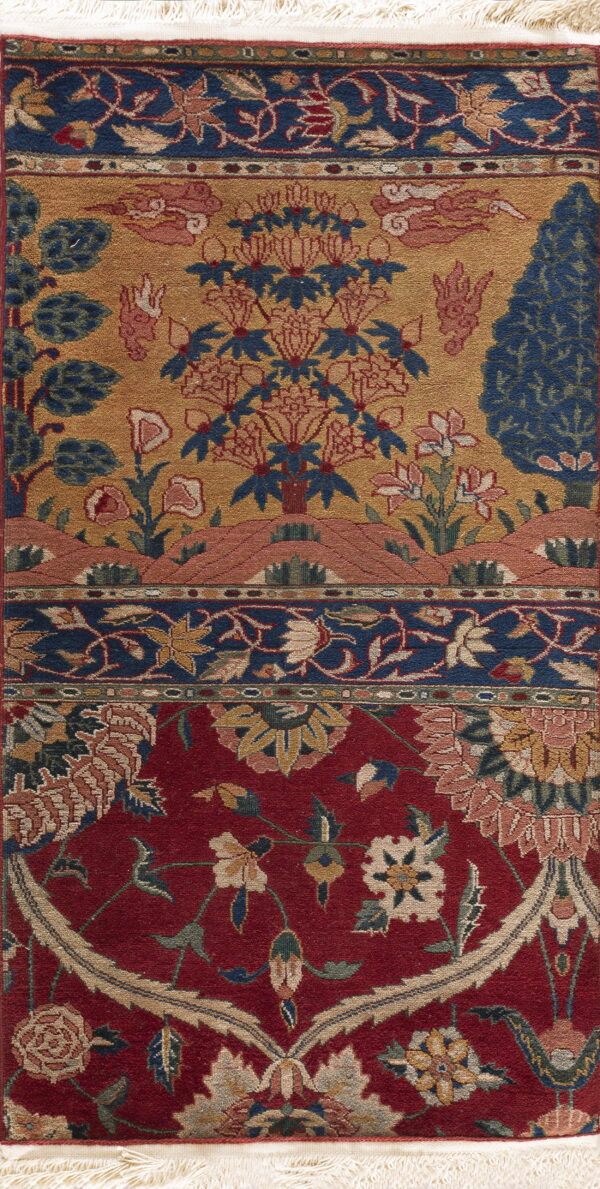 Low pile rug with segmented fields of red floral medallions and gold motifs including trees and clouds.