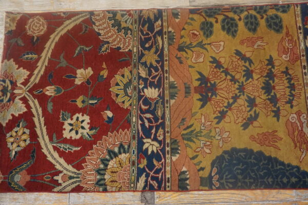 Ornate runner rug with contrasting red and mustard yellow fields separated by a navy floral border.