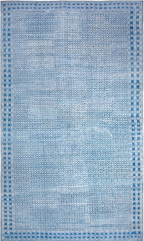 Distressed blue and white rug with an allover quatrefoil repeating pattern and multi-layered geometric borders.