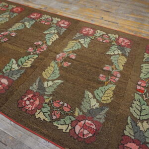Textured brown runner with large repeating pink and green floral wreaths on worn wood flooring.