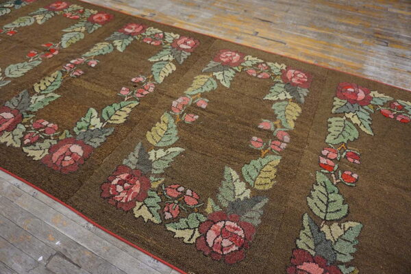 Textured brown runner with large repeating pink and green floral wreaths on worn wood flooring.