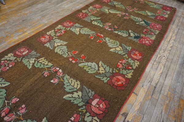 Dark brown textured runner featuring red and green floral garland patterns lies on rustic wooden floors.
