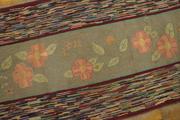 Textured rug displaying a sage floral band bordered by sections of bright multi-colored strips.
