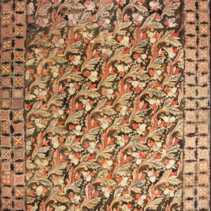 Muted red, cream, and dark brown low pile rug displaying a dense foliage pattern and geometric border.