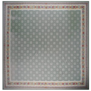 Light green rug patterned with small white flowers and surrounded by a wide multicolored floral border.