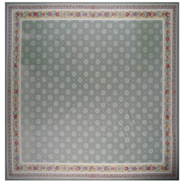 Light green rug patterned with small white flowers and surrounded by a wide multicolored floral border.