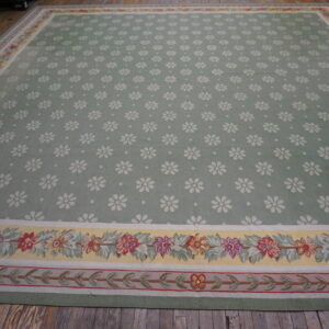 Sage green area rug featuring white scattered daisies and colorful floral borders on rustic wood flooring.
