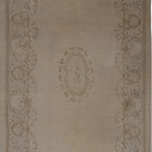 Muted gray rug with faded traditional scrolling floral border and faint central medallion design.