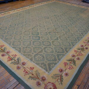 Blue-green flatweave rug with a subtle floral field pattern and a wide yellow border featuring pink and green flowers.