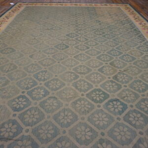 Large light blue rug with a diamond floral trellis pattern and a wide botanical border on wood flooring.