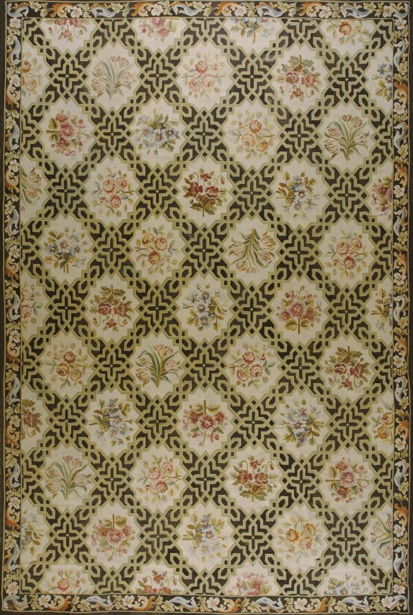 Cream rug with a repeating pattern of dark geometric trelliswork framing pale multicolored floral clusters.