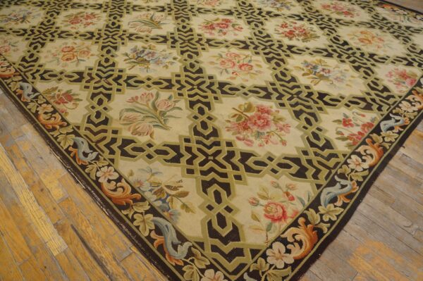 Cream and dark brown rug featuring geometric squares, colorful floral bouquets, and a decorative border on wood floors.
