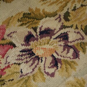 The chunky loop pile shows rose, purple, and beige floral patterns with olive green and gold accents.