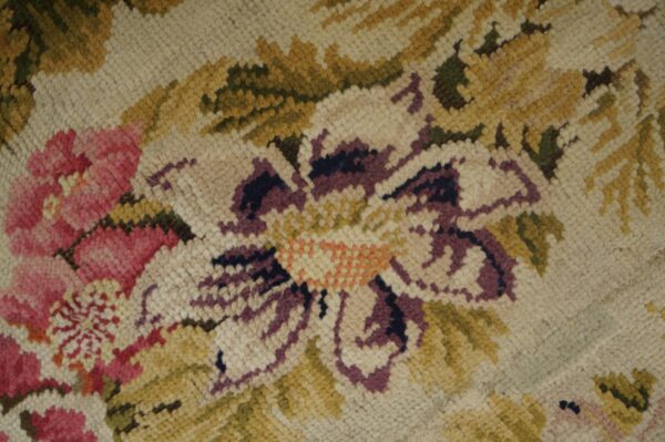 The chunky loop pile shows rose, purple, and beige floral patterns with olive green and gold accents.