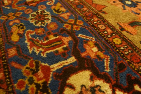 Ornate traditional rug detail in deep blue, red, gold, and tan with medium pile visible.