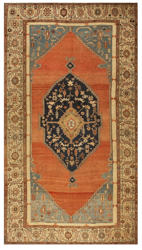 Low-pile rust rug with a geometric navy medallion, light blue spandrels, and complex floral beige border.