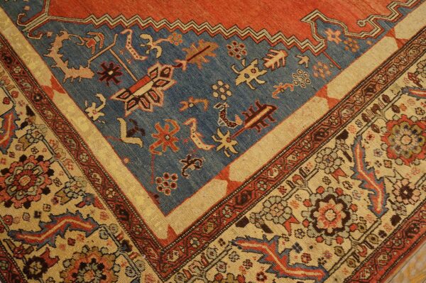 Geometric rug corner featuring a distressed blue field and complex borders in rust red and light tan.