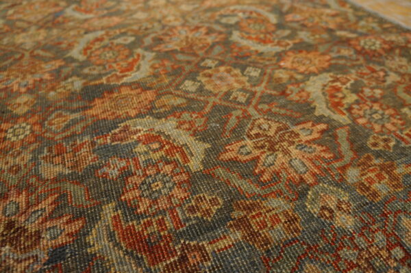 Close-up shows a ribbed, low-pile rug with a dense pattern in deep gray, rust, and sage colors.