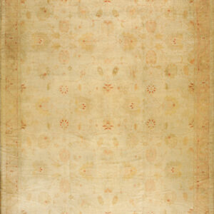 Large faded tan and yellow rug featuring a botanical design outlined in red on a hardwood floor.