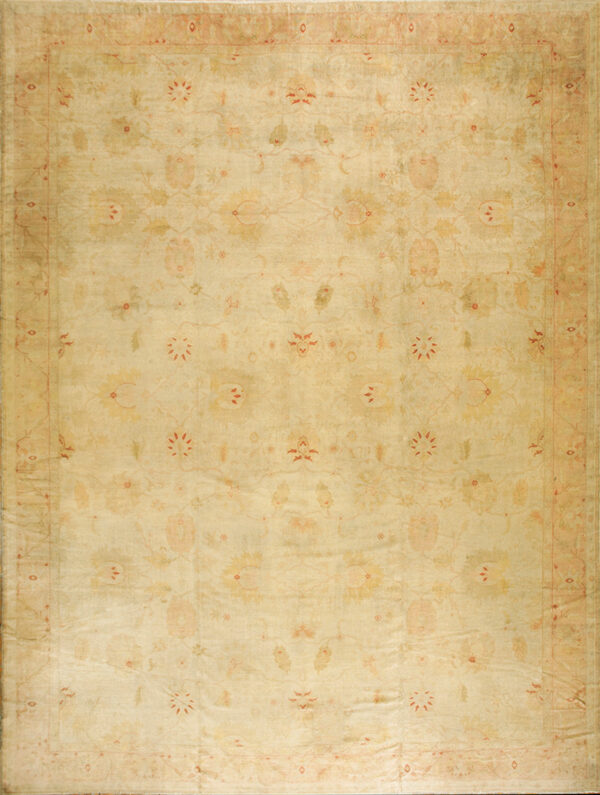 Large faded tan and yellow rug featuring a botanical design outlined in red on a hardwood floor.