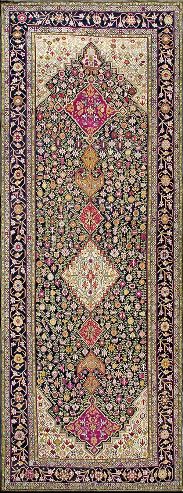 A dark runner rug with a dense floral pattern and alternating magenta and cream geometric center medallions.