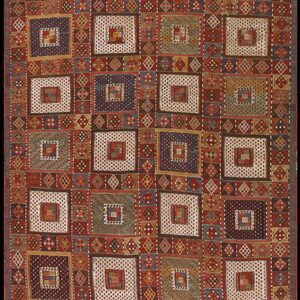 Geometric rug displaying block patterns of nested squares in shades of rust, blue, cream, and green.