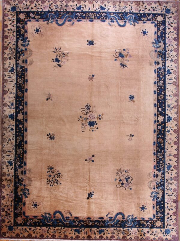 Low pile beige rug with sparse blue and mauve floral sprays and a detailed navy border featuring dragons.