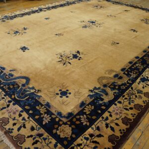Large tan rug with dark blue borders featuring scattered floral motifs and prominent stylized dragons on wood flooring.