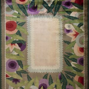 Multicolor rug featuring stylized flowers and leaves bordering a plush rectangular light pink center.