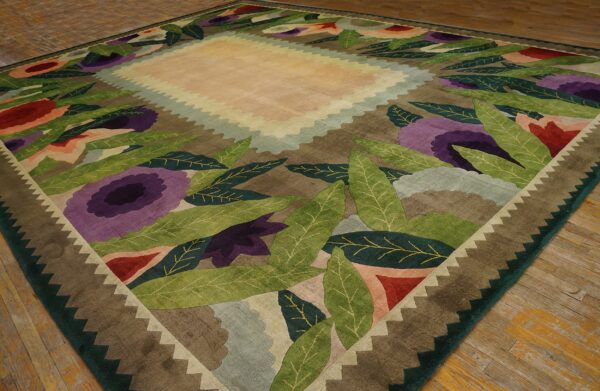 Square rug featuring a bold floral and leaf design in green, purple, and red on brown wood floors.